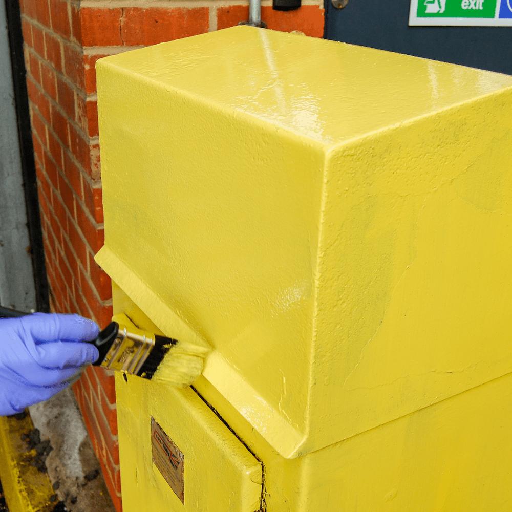 Peinture Multi-Usages jaune appliquée sur une surface métallique au pinceau